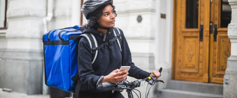 Female gig economy worker using bike to make deliveries